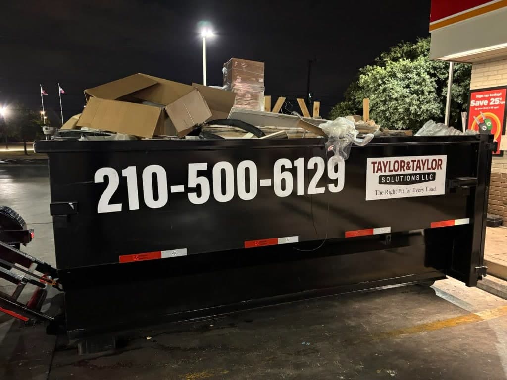 Taylor & Taylor dumpster filled with cardboard at a night commercial job